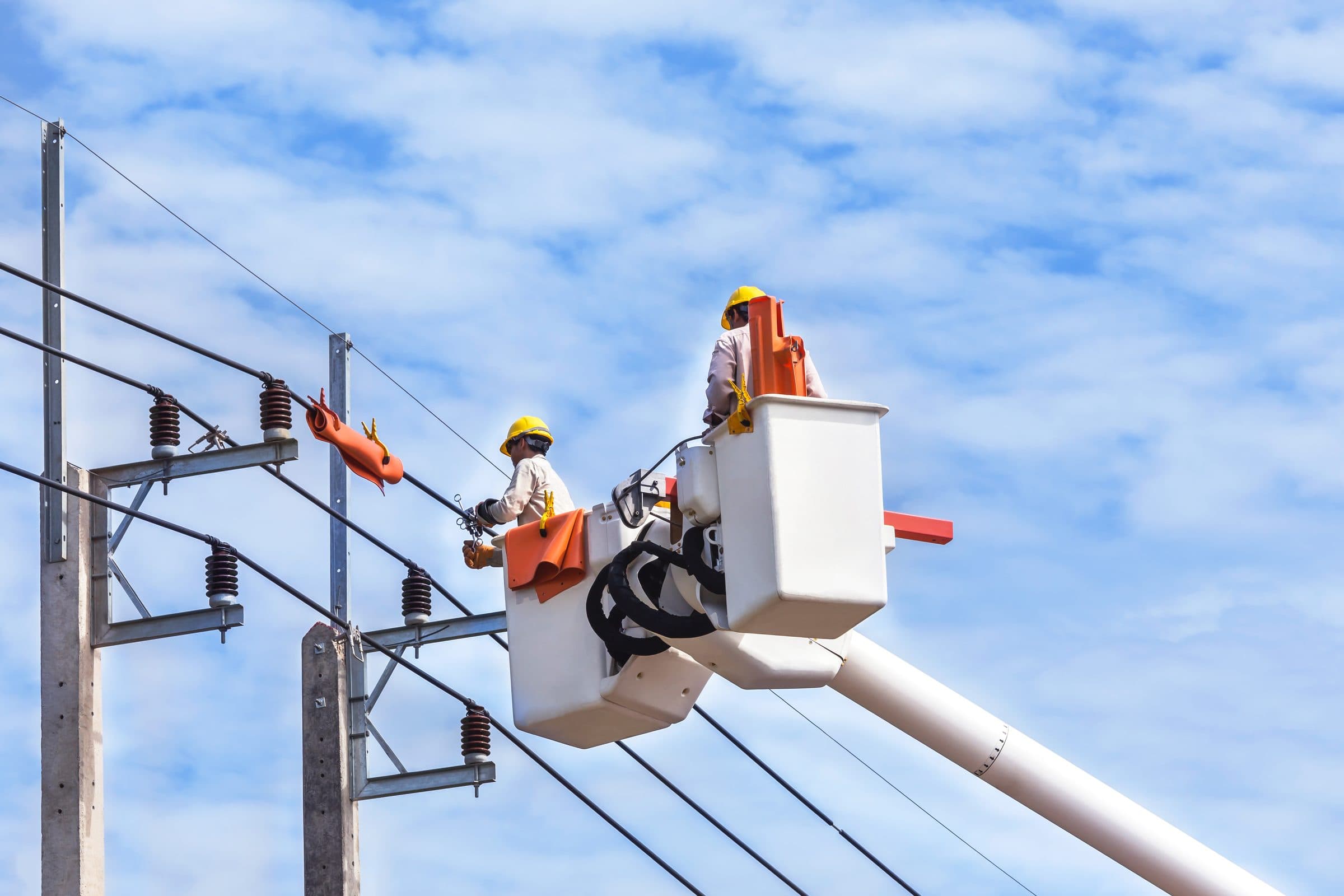 A line crew working from a bucket truck on a clear day
